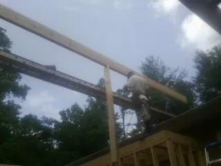 Carpenter setting a ridge beam over a new addition frame — Ice Dam Removal by Roofing Brothers in Joshua