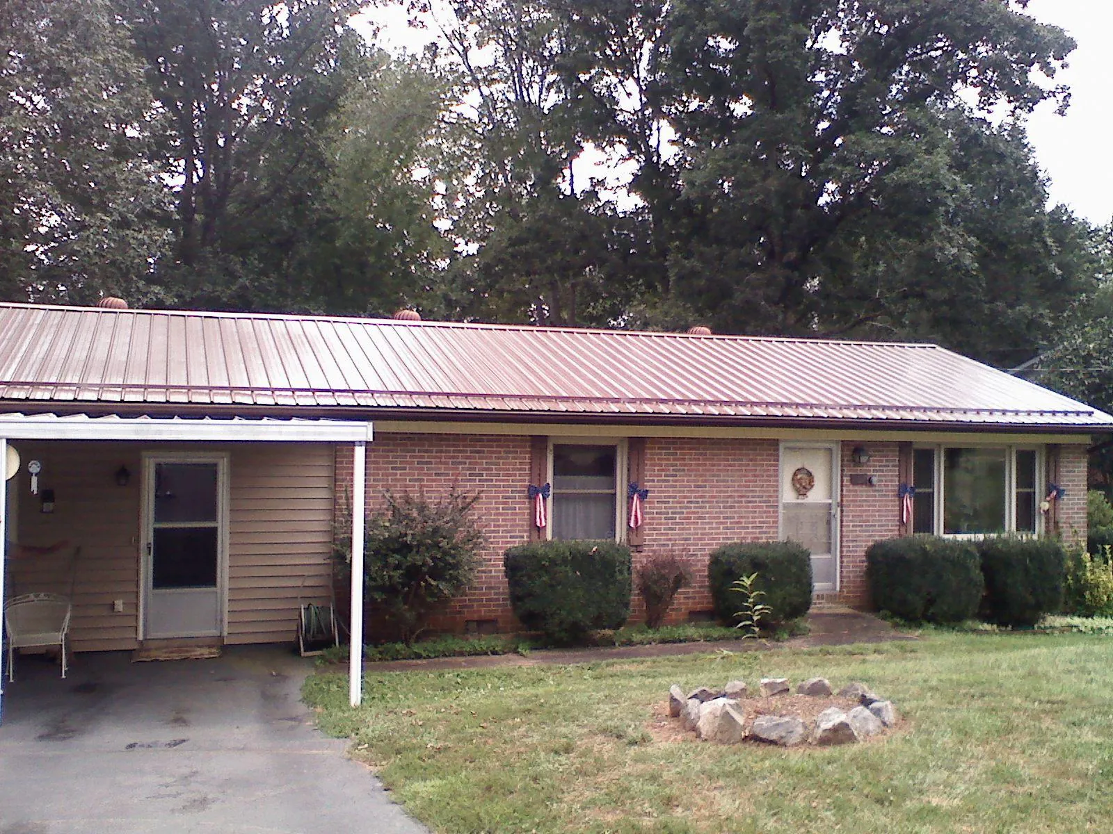 Bronze metal roof and carport on a brick ranch home — Roof Repair work by our crew in Joshua
